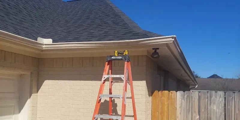 Ladder set against a roofline and gutter during roof work