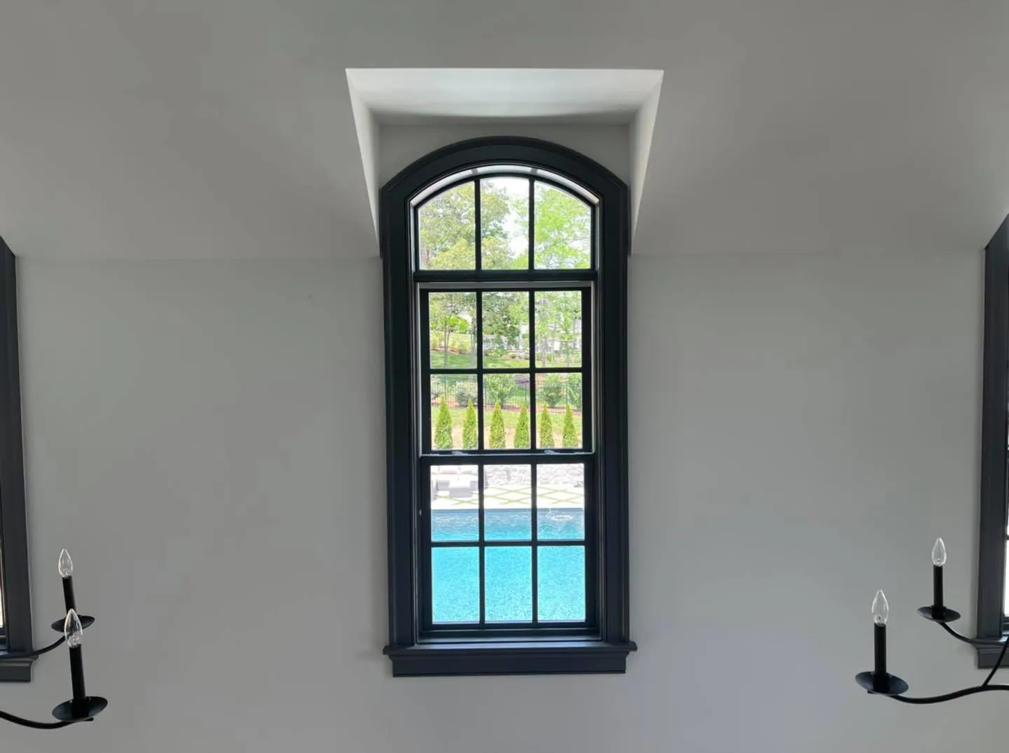 Freshly painted wall around an arched window and sconces