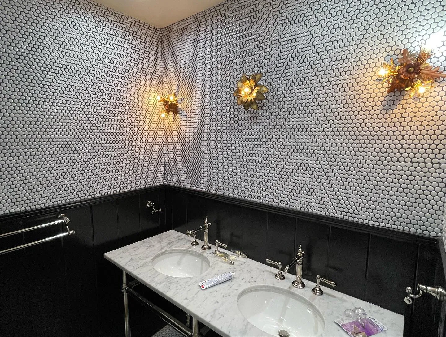 Powder room with penny tile floor and black wainscoting